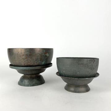 Twee Khmer bronzen ceremoniële waterkommen met sokkel -