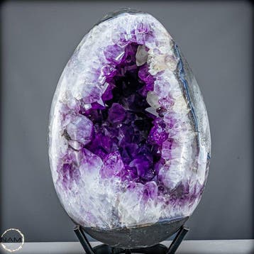 Œuf de cristal d’améthyste majestueux sur un socle élégant