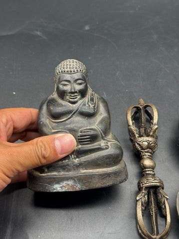 Twee kandelaars, een boeddhistisch standbeeld en een vajra.