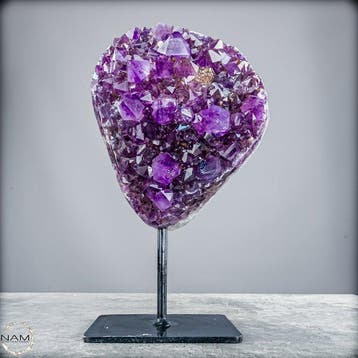Gloeiende amethist op metalen standaard – elegantie in