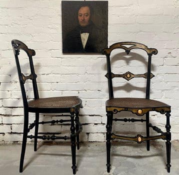 Stoel (2) - Een paar eboniserende stoelen met beeninleg. -