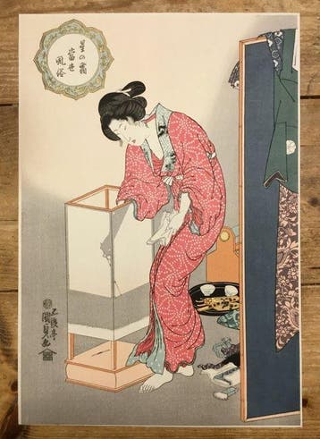 Een vrouw steekt een lantaarn aan - Utagawa Kunisada