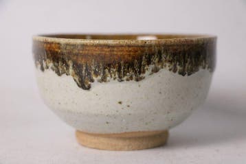Japanse steengoed chawan — amber- en witglazuur theekop met