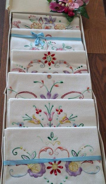 Schattige kleurrijke badhanddoeken met geborduurde bloemen.