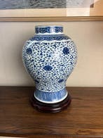 Un bocal bleu et blanc avec des motifs de lotus entrelacés.