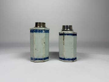 Paar blauwe en witte theebussen met zilverbeslagen deksels.