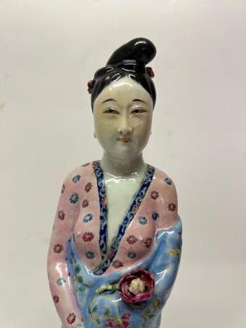 Een verfijnde sculptuur van een Chinese dame in porselein