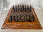 Schaakspel - Spelbord van hout met reliëf en bronzen figuren
