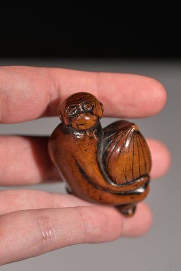 Een zachte netsuke van boxhout in de vorm van een aap met