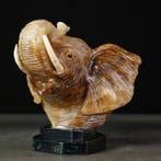 Handgesneden onyx olifantshoofd op zwarte marmeren sokkel -