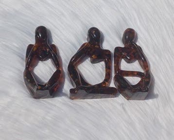 Trois sculptures en ambre balte recouvertes de résine. -