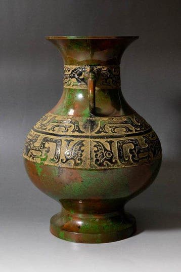 Vase en métal patiné au design archaïque et à deux anses. -
