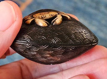 Een netsuke van een hertenhoorn met een krab die op een