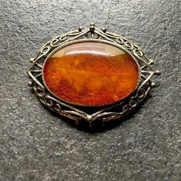 Oude opengewerkte broche met natuurlijk Baltisch barnsteen.