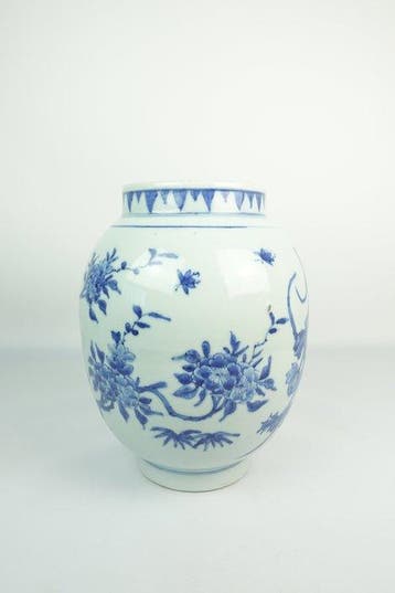 Blauw-witte vaas met bloemmotieven van geplukte takken -