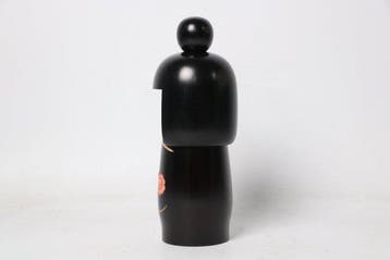 Zwarte kokeshi-pop met camelia — werk bekroond met de