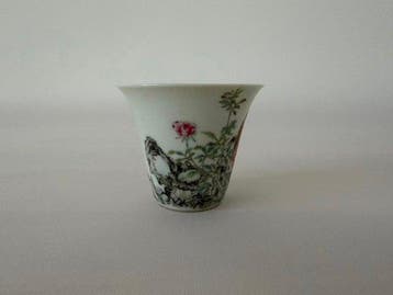 Een Chinees porseleinen kopje in famille rose, versierd met