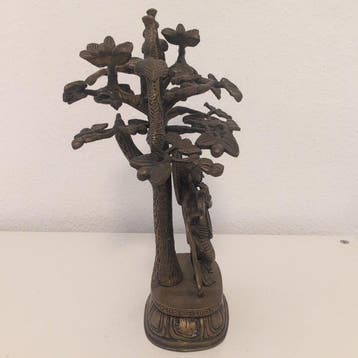 Grote bronzen figuur van Krishna met fluit onder een boom en