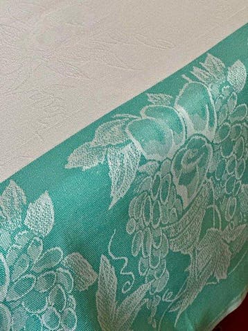 Nappe damassée blanche et verte, décorations frugales. -