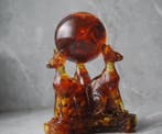 3 Baltische amber Sphynx katten die een amberbal vasthouden