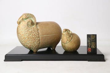 Gegoten metaal met een gouden en groene patina-afwerking. -