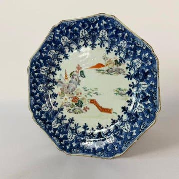 Een blauw-witte schotel met overglazuur in Famille