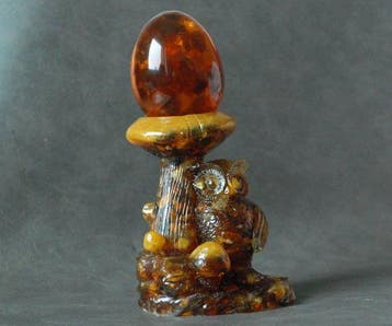 Amberkleurig uil-beeldje met een paddenstoel die een