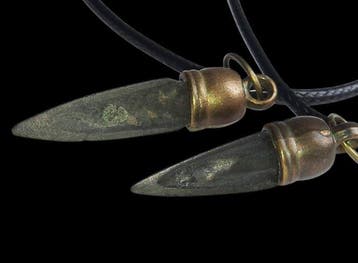 Scythe Bronze Deux pendentifs en forme de pointe de flèche.