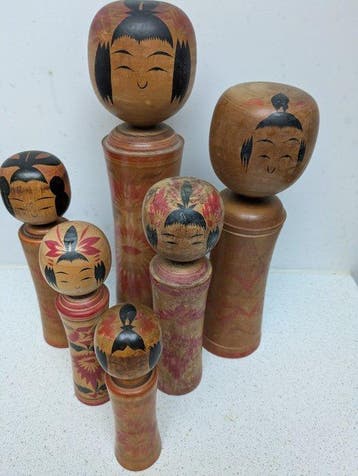 Een set vintage kokeshi-poppen in de klassieke Naruko-stijl