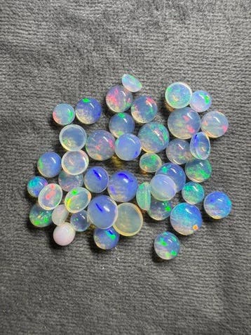 Lot van 12,50 karaat cabochons van witte opalen, rond. Geen