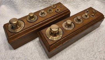 Twee eikenhouten blokken met messing knopgewichten –