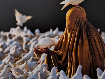 Steve McCurry (1950–) - Woman feeds doves in Mazar-i-Sharif.