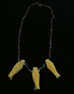 Replica van een amulet-sieraad van faience keramiek uit het