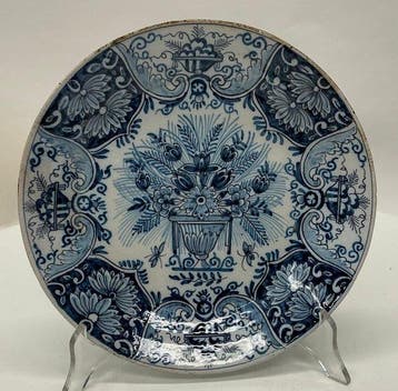 Delfts blauw bord met bloemenvaas en lambrequinrand – 18e