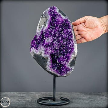 Gloeiende amethist op metalen standaard – elegantie in