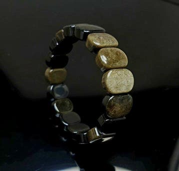 Hoogwaardige goudkleurige obsidiaanarmband. Zeer heldere