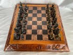 Schaakspel - Spelbord van hout met reliëf en bronzen figuren