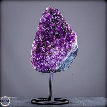 Gloeiende amethist op metalen standaard – elegantie in