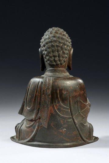 Une grande statue en bronze d’un Bouddha tenant la Roue du
