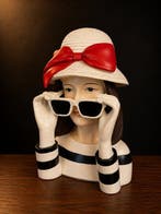 sculptuur, Elegante fashion lady met zonnebril en rode strik