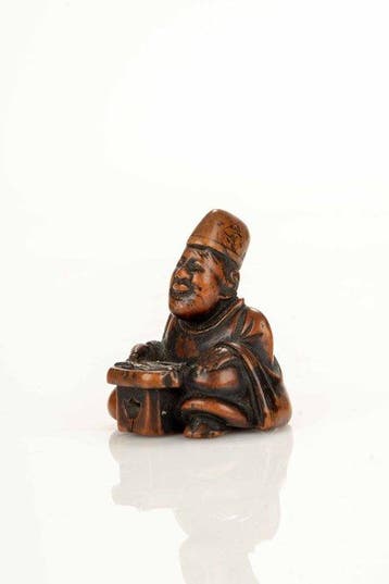 Een grote buxushouten netsuke van een zittende monnik