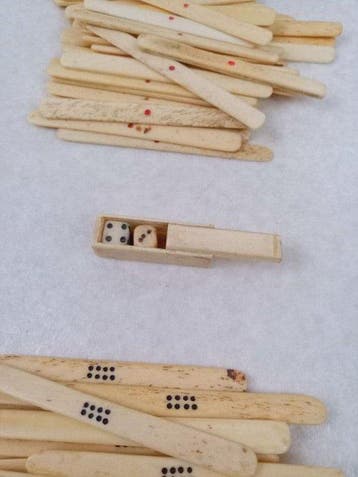 Antieke mahjongset van bot en bamboe met houten kast met