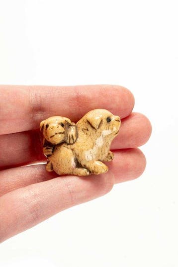 Een fraaie en zachte hertengewei netsuke die twee pups