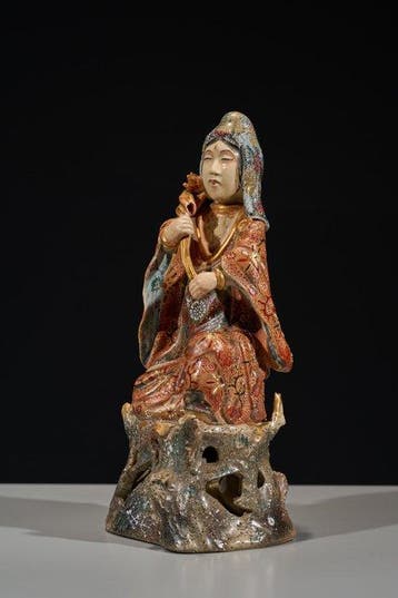 A Japanese Satsuma okimono of Kannon holding a lotus flower