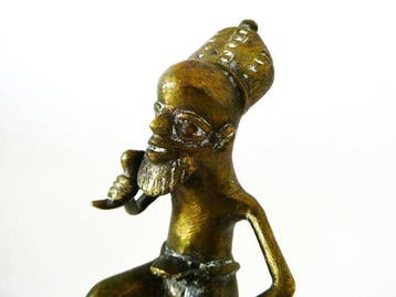 Primitief sculptuur van een Afrikaanse man met een hoorn in