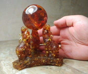 3 Baltisch Amber-olifanten die een Amberbal vasthouden -