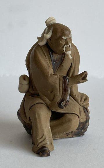 Okimono van terracotta dat een oude wijze voorstelt die op