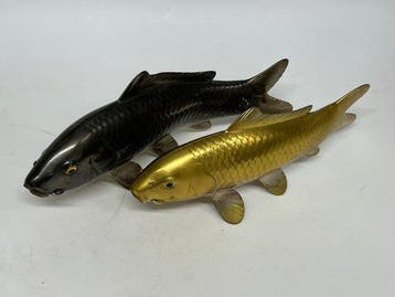 Een levensechte bronzen sculptuur van een paar koi-karpers,
